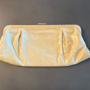 Cream color leather clutch with metal clasp.